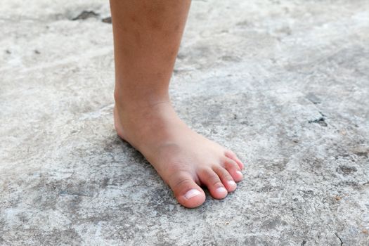 Children feet on the concrete.
