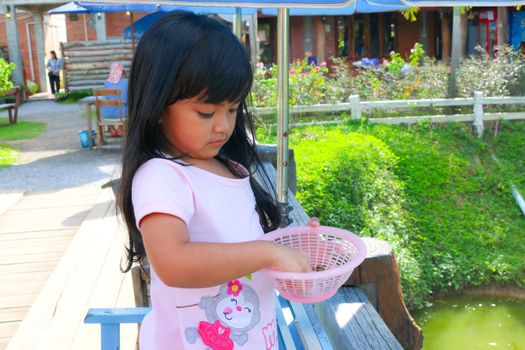 Pretty girls are feeding fish.