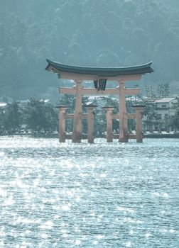 Floating gate (Giant Torii) of Itsukushima Shrine at sunny day in Hiroshima, Japan. The temple is a UNESCO World Heritage Site.