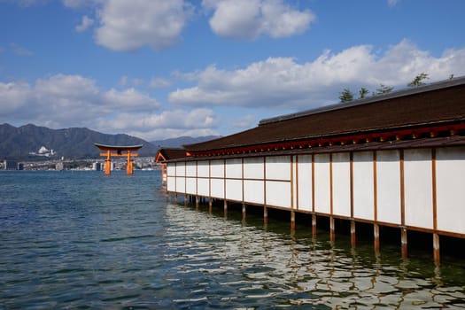 Itsukushima Shrine with Giant Torii on the island in Hiroshima, Japan. The historic shrine complex is listed as a UNESCO World Heritage Site.