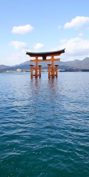 Floating gate (Giant Torii) of Itsukushima Shrine at sunny day in Hiroshima, Japan. The historic shrine complex is listed as a UNESCO World Heritage Site.