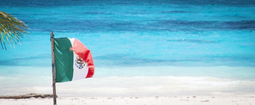 A Mexican flag on a beach