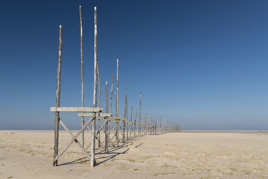 Old pier on the sandbar the Vliehors on the island of Vlieland in the Netherlands
