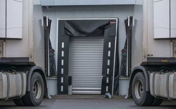 2 Lastwagen zur Entladung oder Beladung am Depot einer Spedition.
