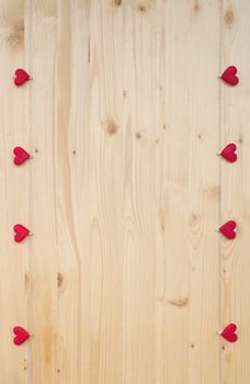 Eight hearts with clothes pegs on a cord on wood