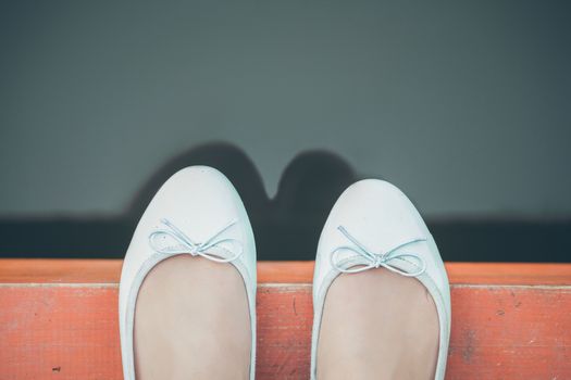 Female feet on the edge of the pier