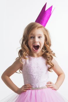 Little princess girl in pink crown and beautiful dress on white background