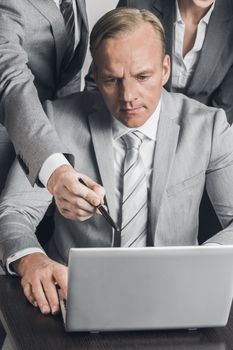 Group of business people working together with laptop at meeting