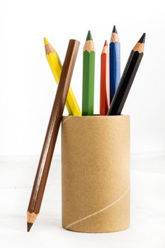 Colorful baby crayons in a cup on a white background