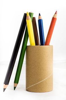 Colorful baby crayons in a cup on a white background