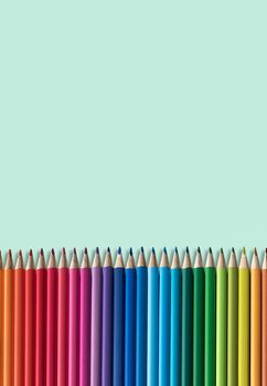 Set Of Children's Colouring Pencils On A Green Background Wth Copy Space
