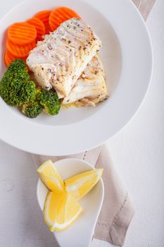 Healthy lunch with cod and steamed vegetables