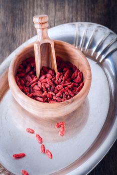 Dried goji berries with wooden spoon on a tray