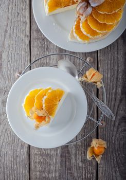 A Cheesecake decorated with oranges and physalis