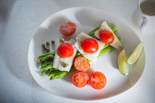 Mackerel fillets with asparagus on a white plate