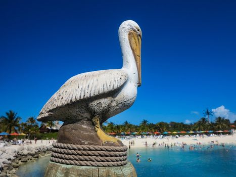 A pelican statue by the beach and ocean