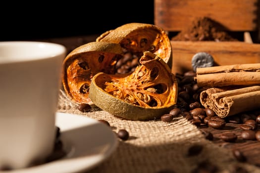 Close-up on dried orange fruit and cinnamon sticks with coffee beans