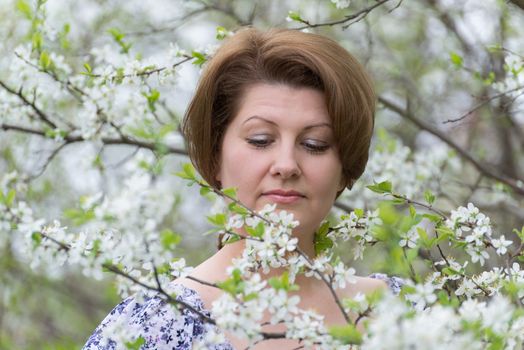 A woman in an apple orchard in early spring