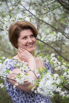 A woman in an apple orchard in early spring