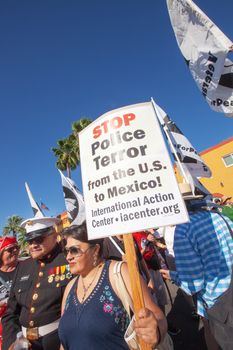 NOGALES, AZ - OCTOBER 08: Woman holding large picket sign at border policy protest march at the United States and Mexico boundaries on October 08, 2016 in Nogales, AZ, USA.