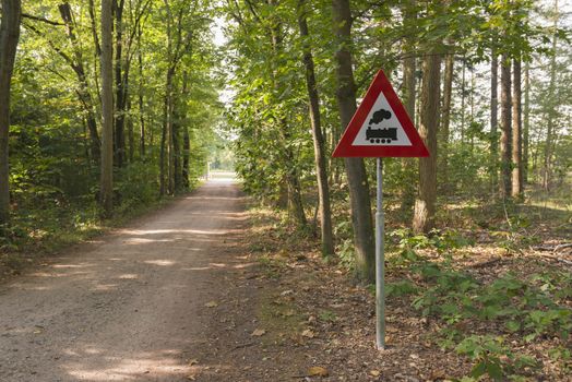 Warning sign with meaning level crossing without barriers in the forest in the Achterhoek region between Aalten and Winterswijk
