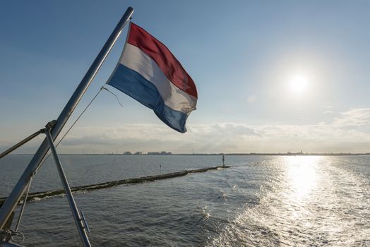 Wadden Sea with Dutch flag as seen from the ferry     
