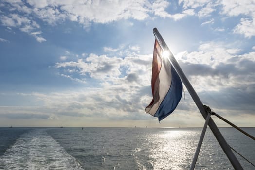 Wadden Sea with Dutch flag as seen from the ferry     
