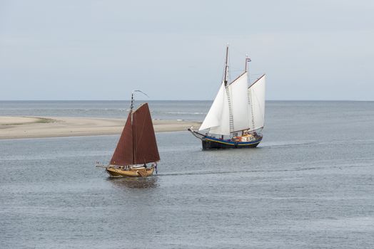 Old historic sailing boats on the edge of the North Sea and Wadden Sea near the wadden Island Vlieland
