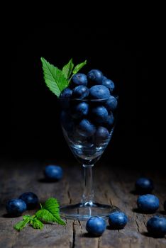 Blueberries with leaves in small glass