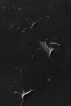 Cracking and peeling black paint on a wall. Vintage wood background with peeling paint. Old board with Irradiated paint