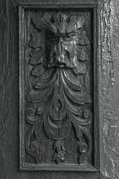 Ancient bas-relief face. Cracking and peeling paint on a wall. Vintage wood background with peeling paint. Old board with Irradiated paint