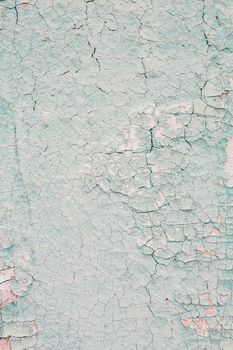 Cracking and peeling blue paint on a wall. Vintage wood background with peeling paint. Old board with Irradiated paint