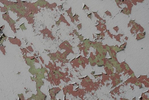 fragment of an iron surface is covered with grey color paint, which has long been under the influence of different climatic conditions