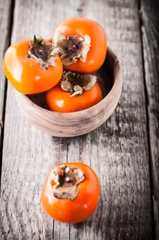 Fresh Ripe Persimmons placed on a wooden table