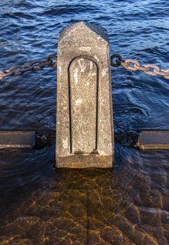 A concrete pylon maintains a barrier along the St. Croix River in Stillwater, Minnesota despite floodwaters creeping in.