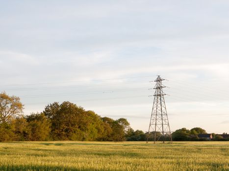 a farm field outside as the sunsets with a serene sky and a pylon wonderful and peaceful with no people