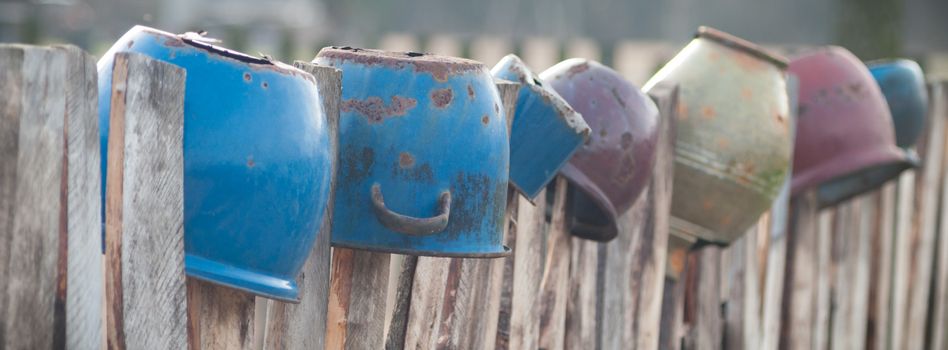 Old wooden boundary fence with nails on sunny day