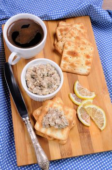 Appetizer of fish paste (forshmak) on a cracker with a cup of coffee