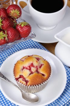 Muffin filled with strawberries on a table  cup of coffee