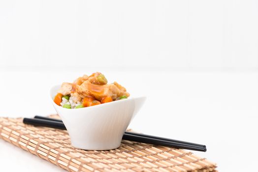 Small bowl of general tao spicy chicken served on vegetable rice.