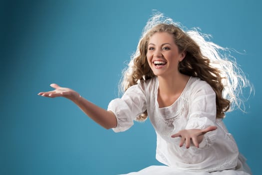 Young smiling beautiful woman on a studio background