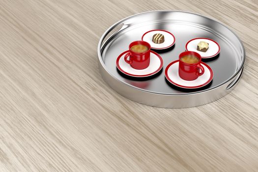 Silver tray with espresso coffee cups and chocolate candies on wooden table