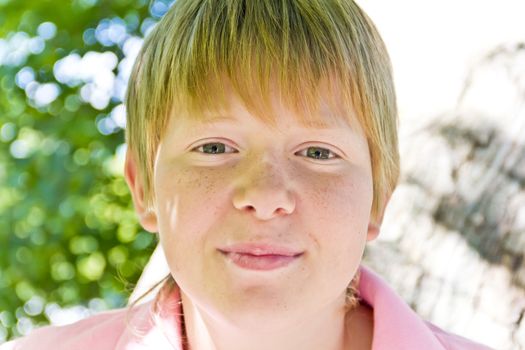 Portrait of blond boy in a pink shirt