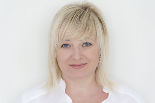 Horizontal portrait of blond woman with blue eyes in white