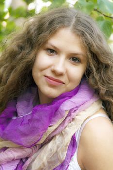 Young beautiful girl with curly hair in purple scarf