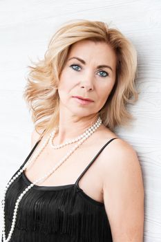 Vertical portrait blond woman with pearl beads on white background