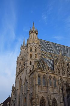 St Stephen Cathedral (Stephansdom) at Stephansplatz, the biggest cathedral and most important religious building in Vienna, Austria, over day blue sky, low angle view