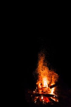 Campfire with flying sparks isolated on black background