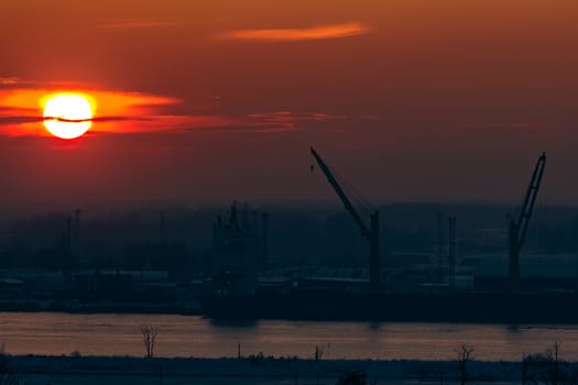 Hot orange sunset over the river. Urban landscape