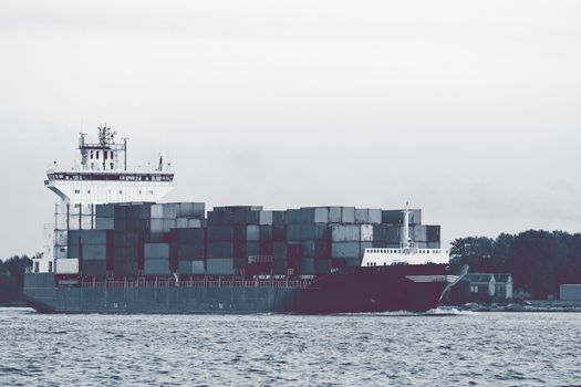 Full container ship moving to Baltic sea. Riga, Latvia